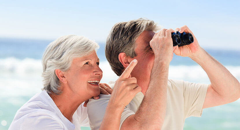 Couple on beach with binoculars