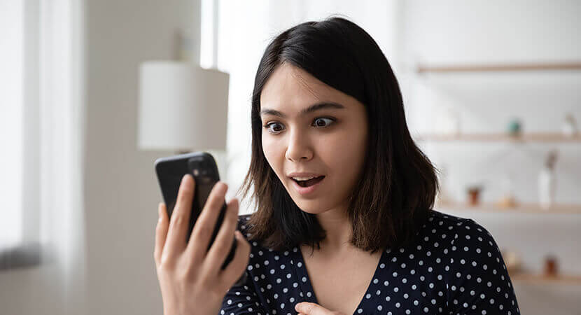 Excited woman looking at phone